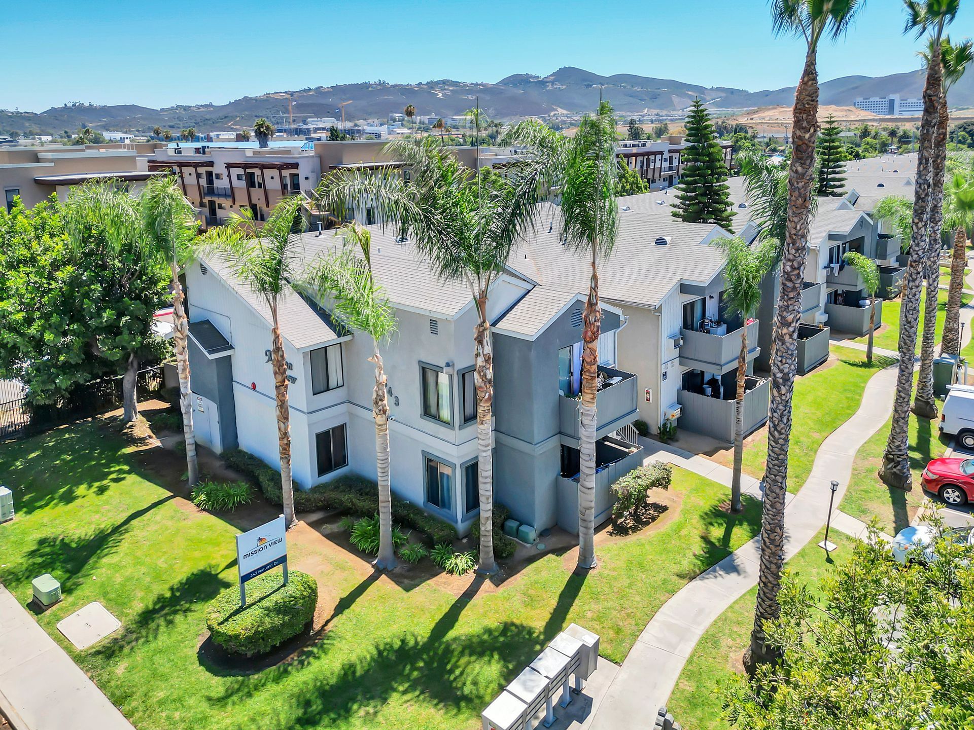 An aerial view of a apartment complex with palm trees