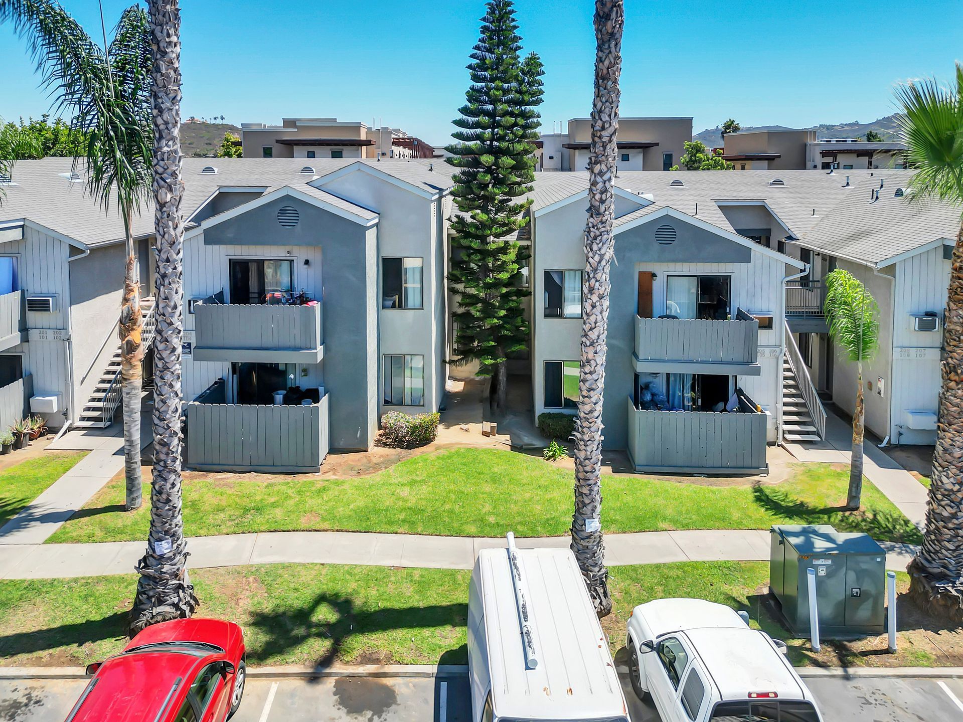 An aerial view of a apartment complex with cars parked in front of it