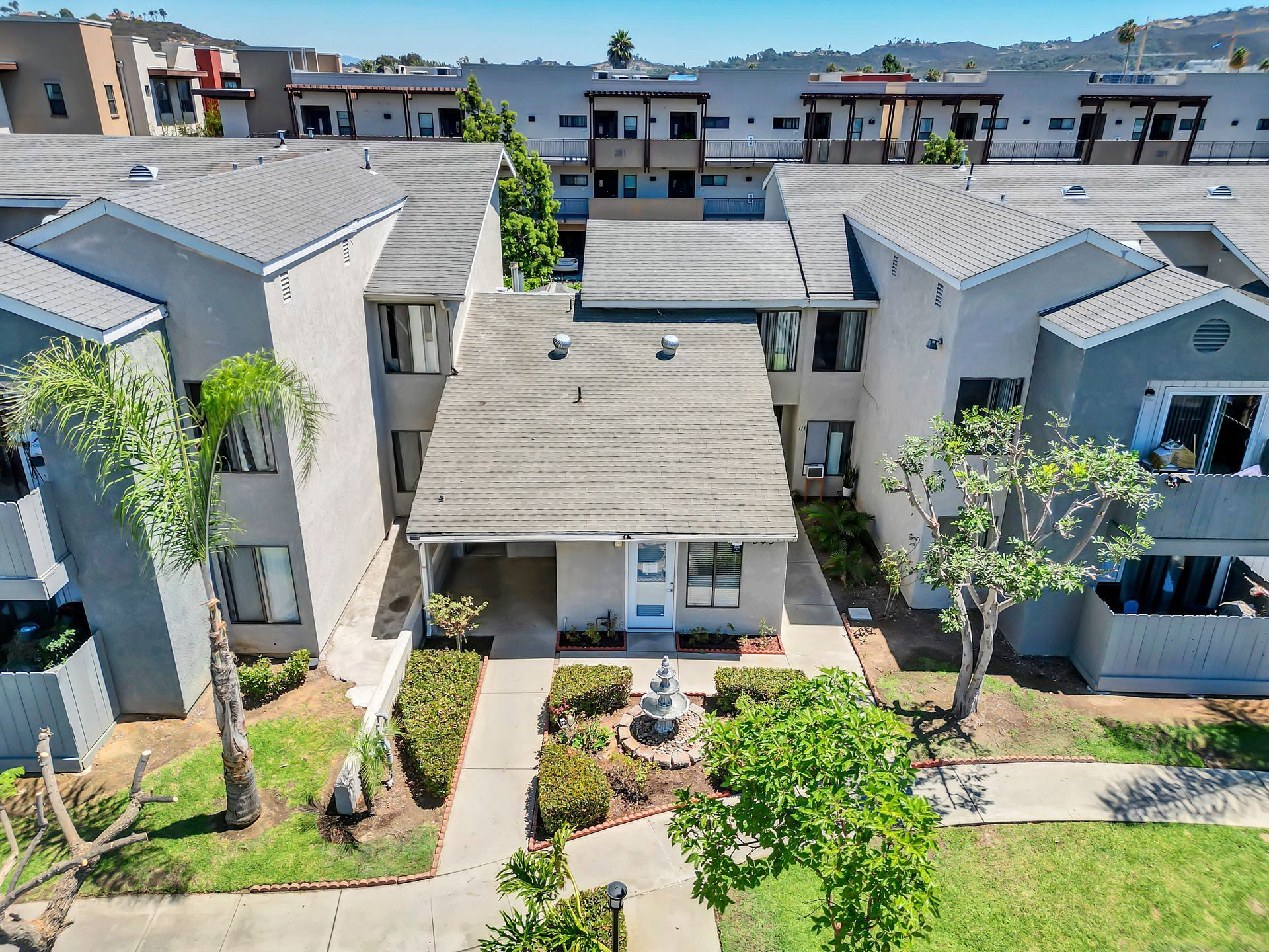 An aerial view of a apartment complex with a house in the middle