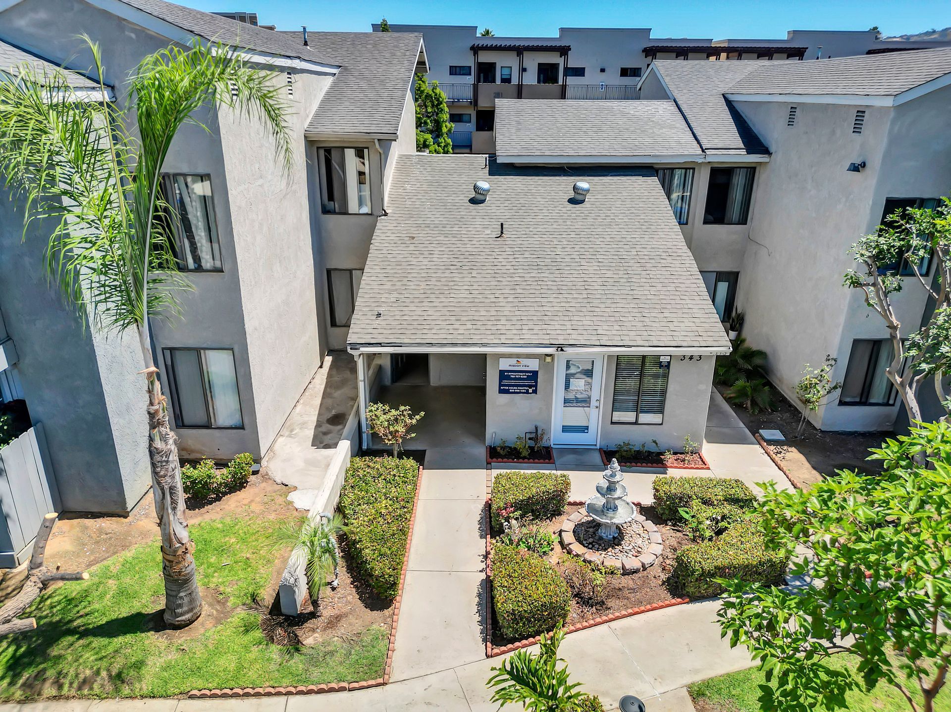 An aerial view of a building with a fountain in front of it