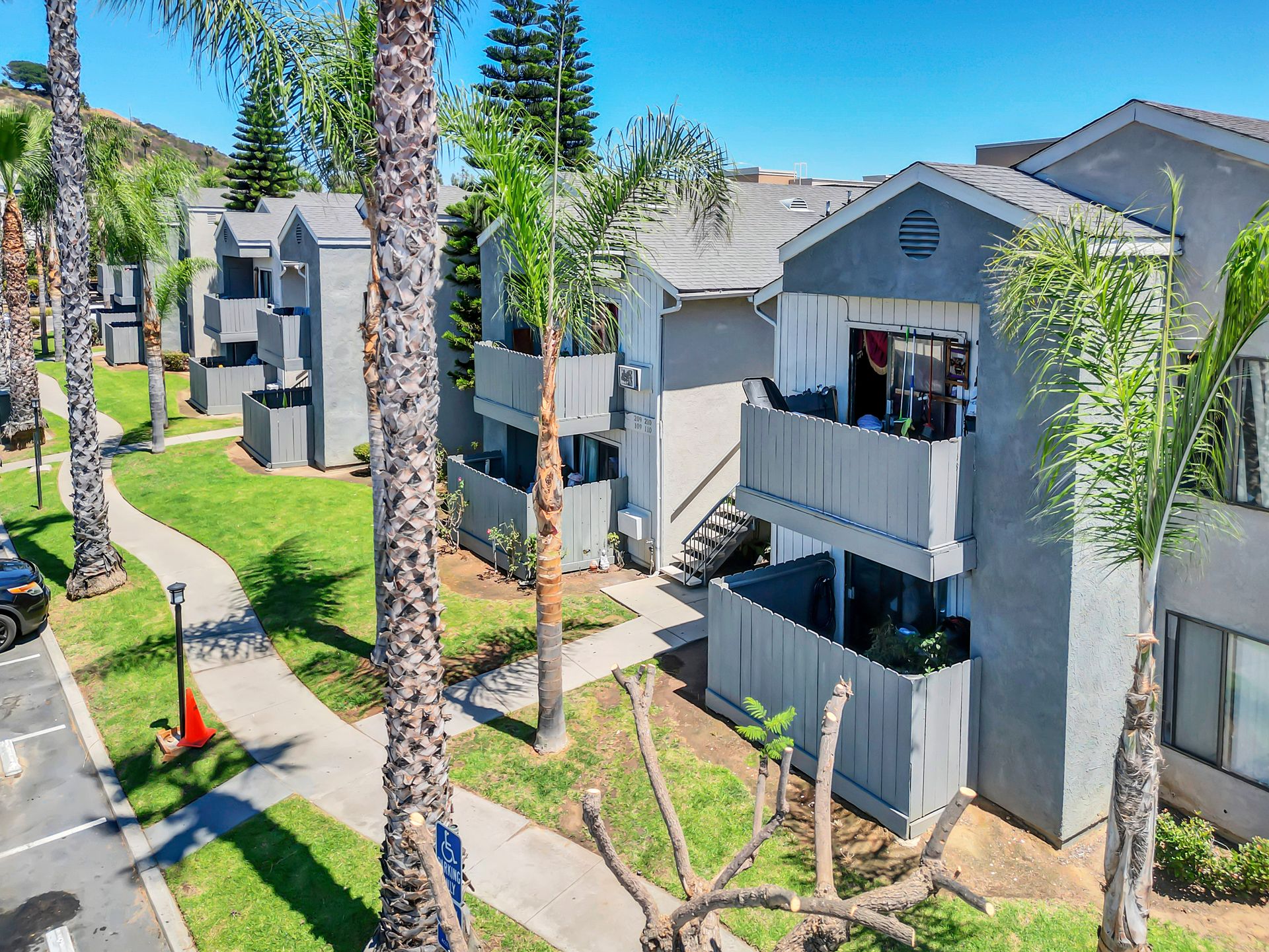 An aerial view of a row of apartment buildings surrounded by palm trees.