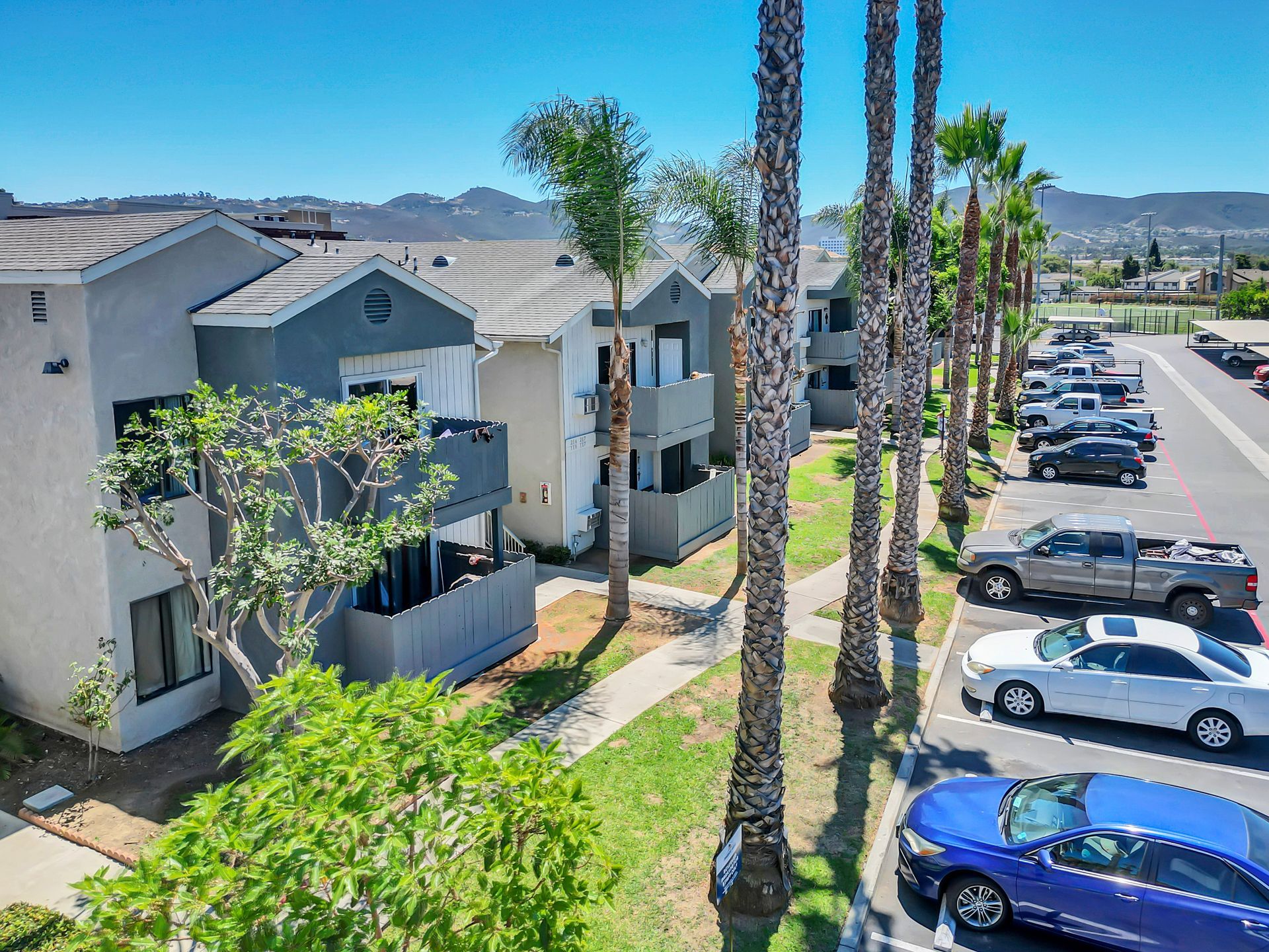 A row of cars are parked in front of a building.