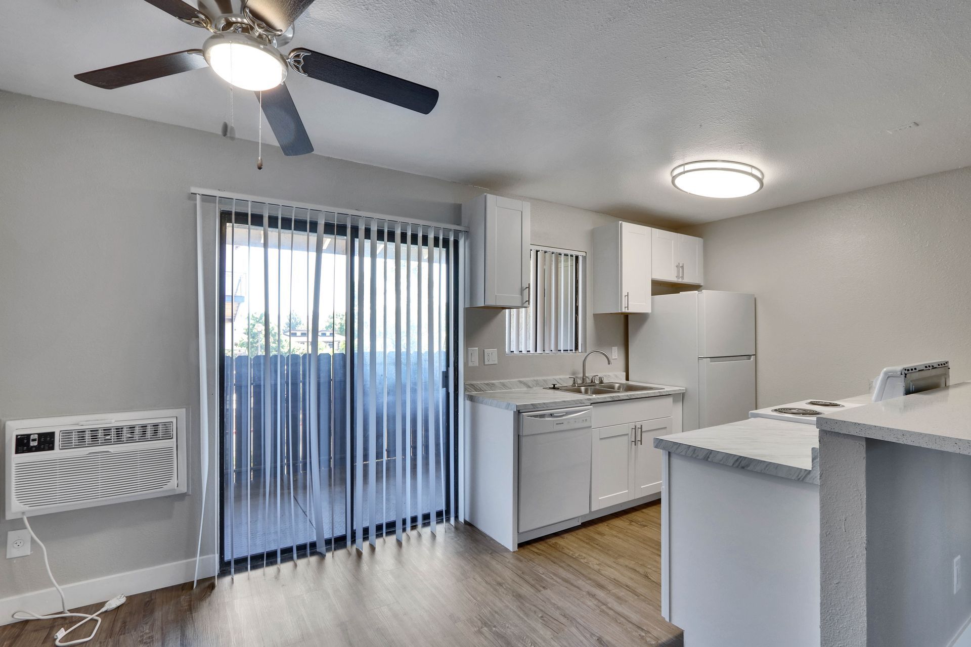 A kitchen with sliding glass doors and a ceiling fan