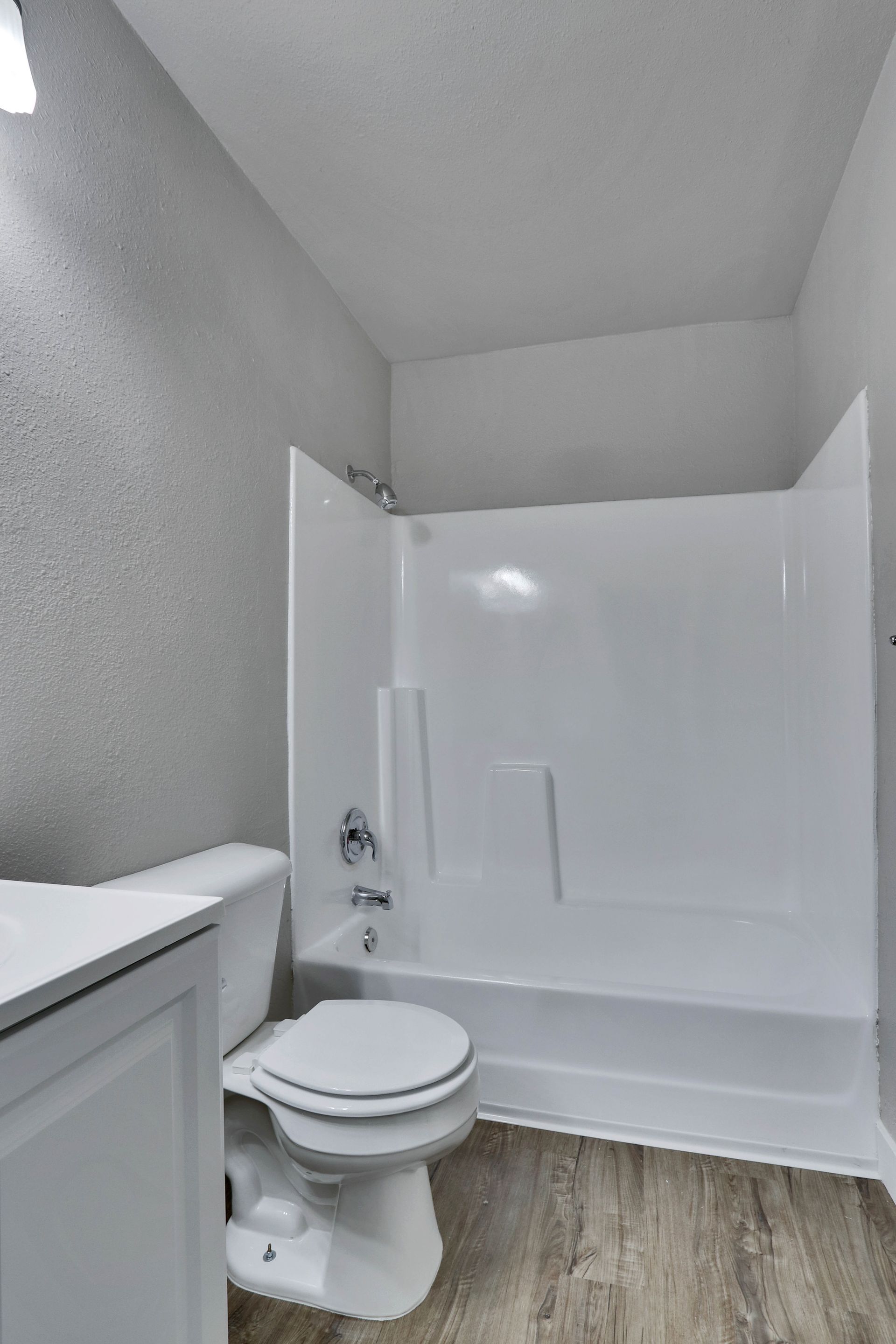 A bathroom with a toilet , sink , tub and shower.