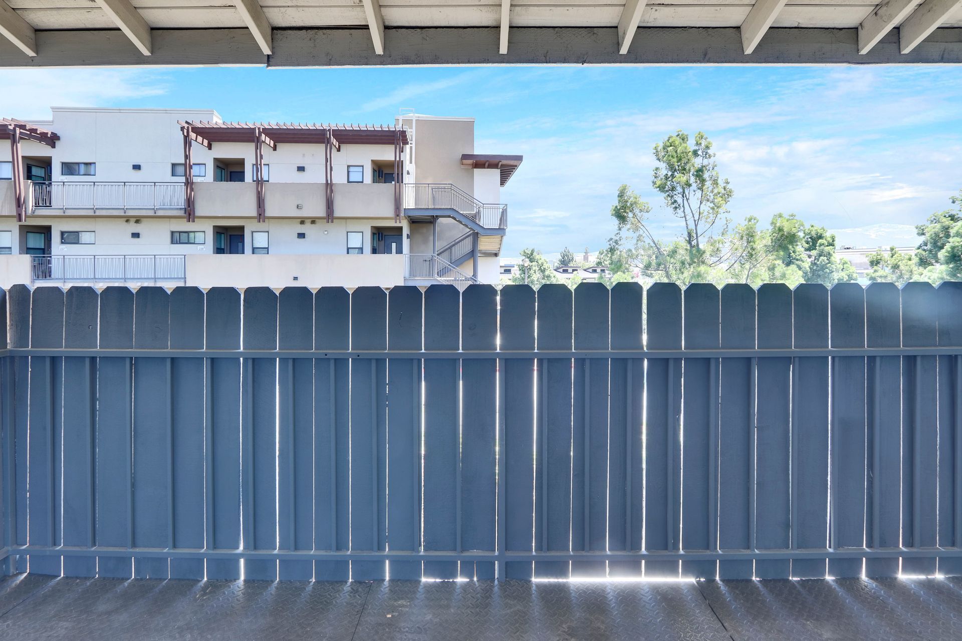 A wooden fence with a building in the background