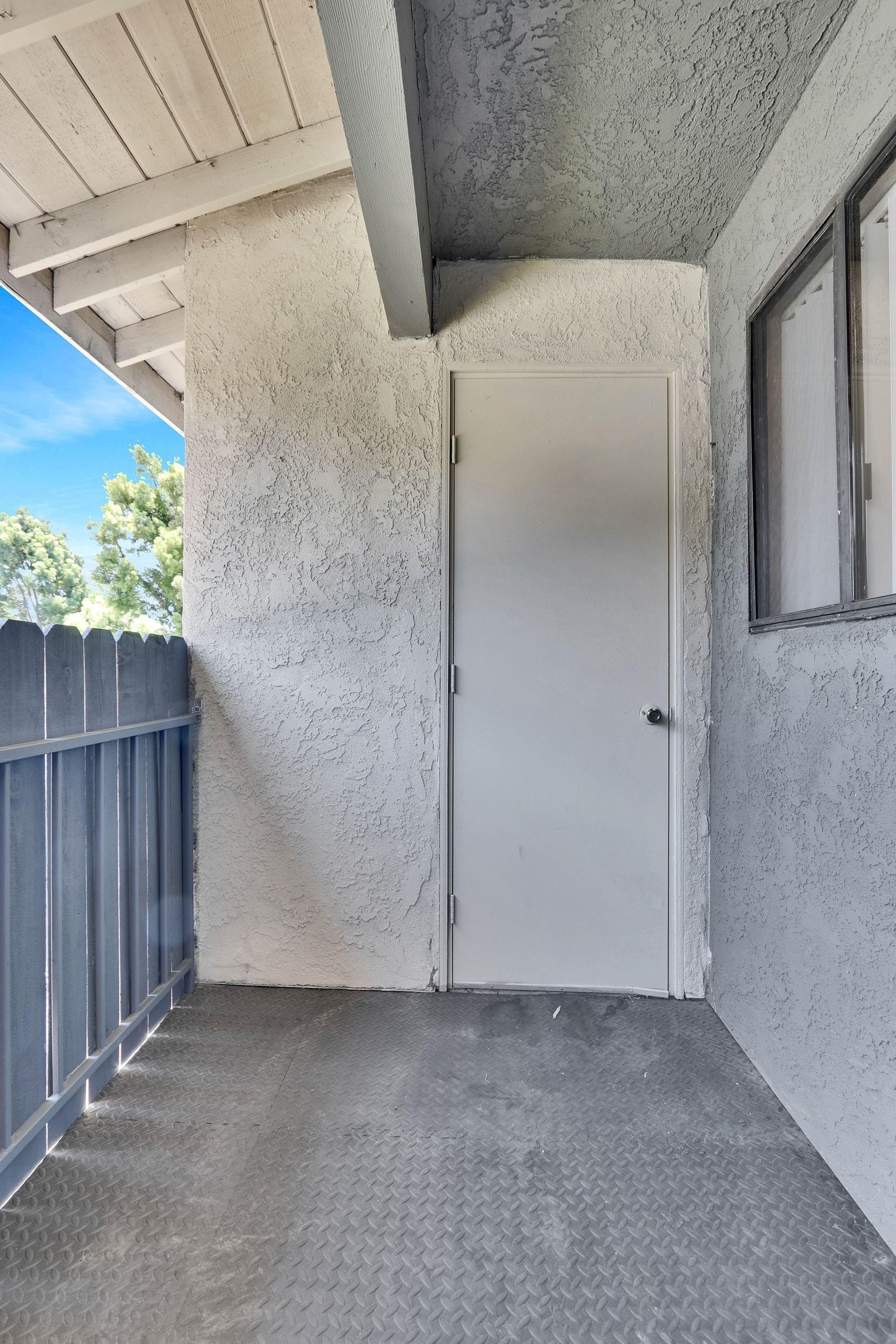 A balcony with a white door and a window.