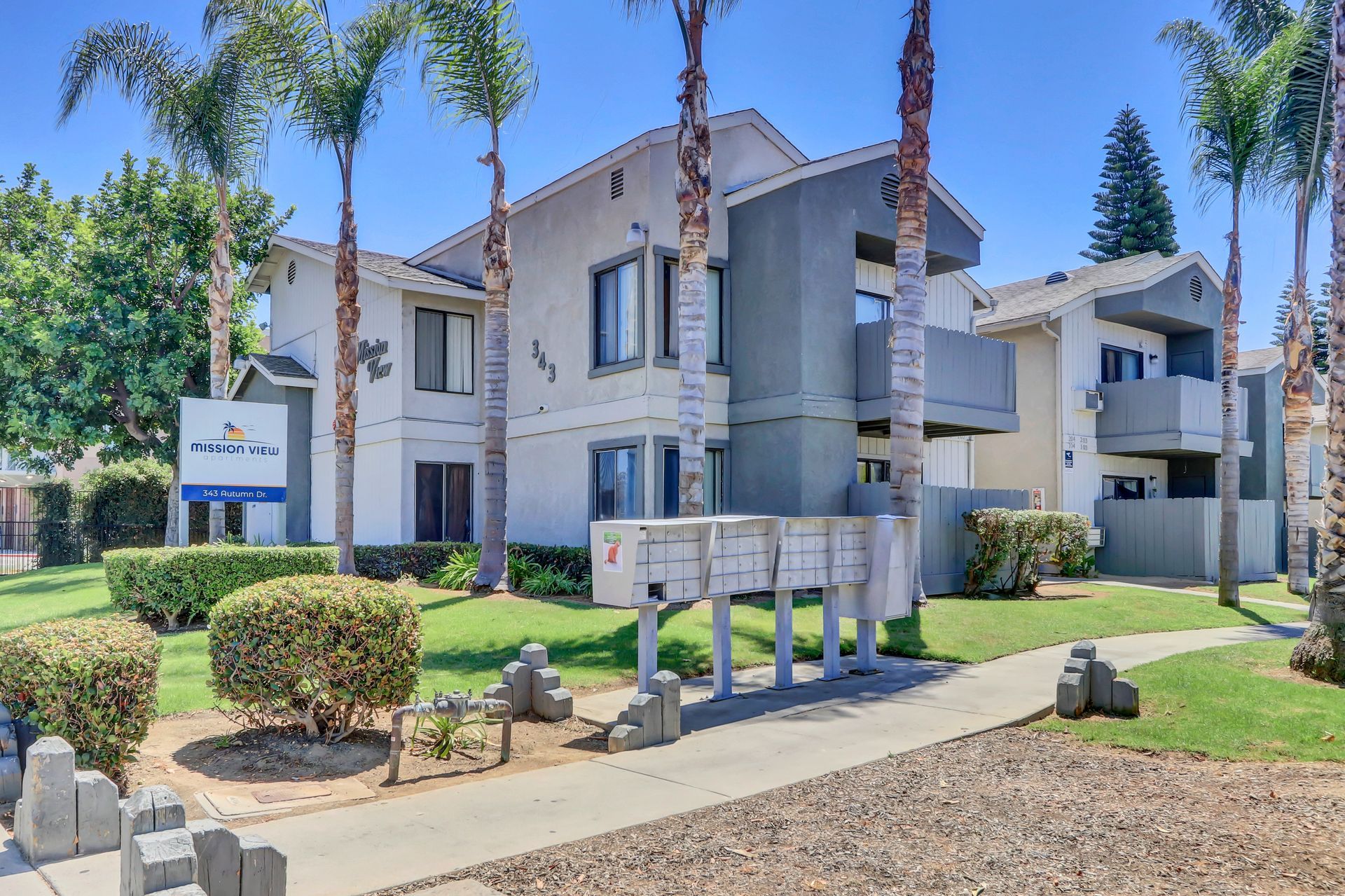 A large apartment building with palm trees in front of it