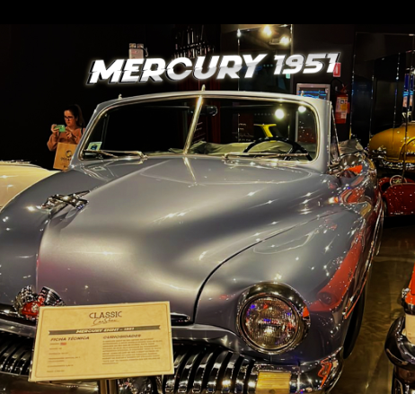 Mercury conversível 1951 em um museu, com uma pessoa tirando uma foto. Placa com os dizeres