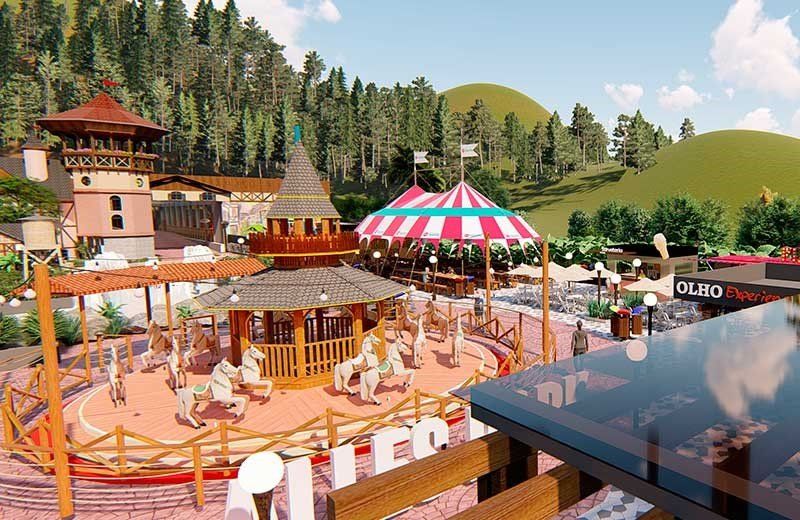 Um carrossel colorido com cavalos brancos em um cenário de parque com árvores e colinas.