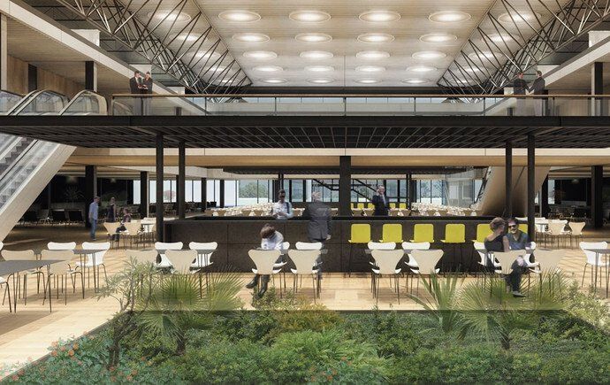 Vista interna de um grande café com mesas, bar e um jardim submerso. Pessoas presentes.