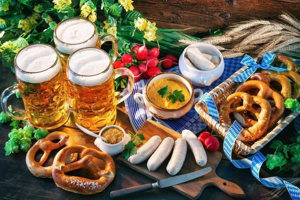 Pratos típicos da Oktoberfest: canecas de cerveja, pretzels, salsichas, mostarda, rabanetes e molho.