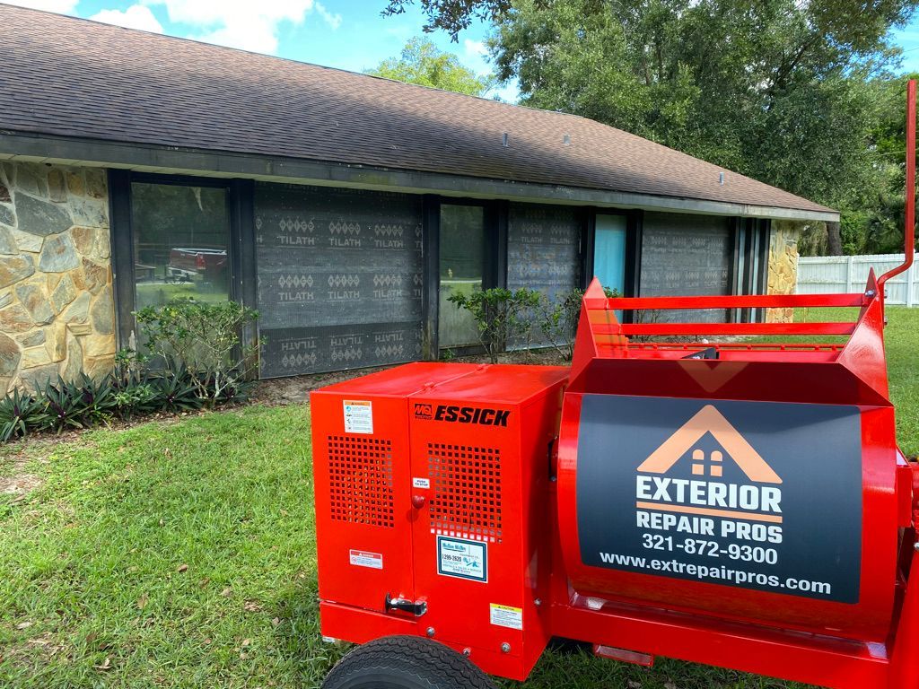 Red equipment in front of a house, advertising Exterior Repair Pros.