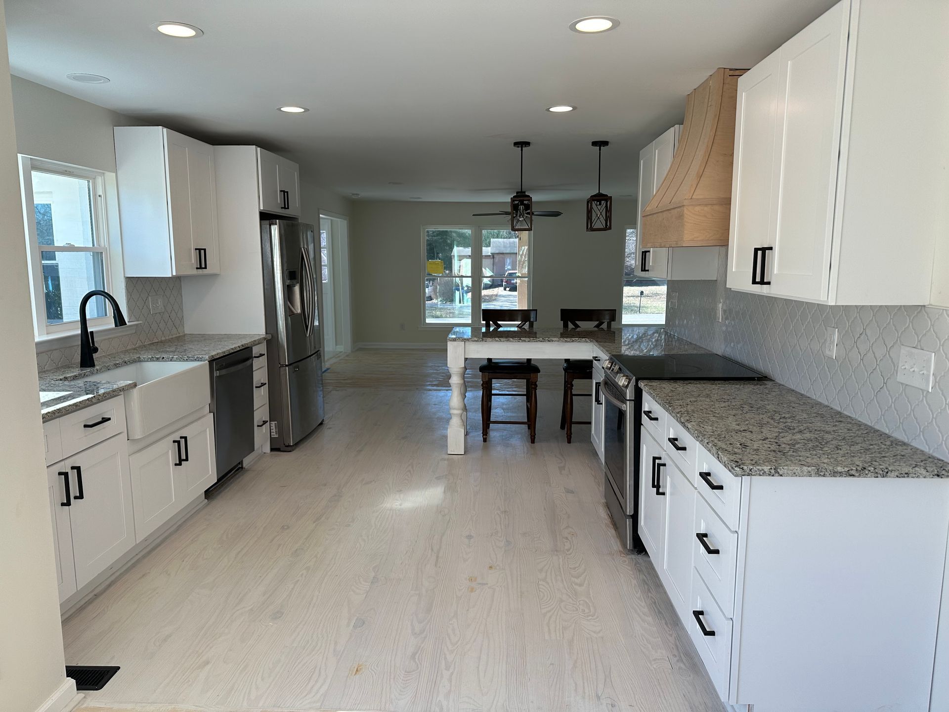 Modern kitchen with white cabinets, stainless steel appliances, and a central island.