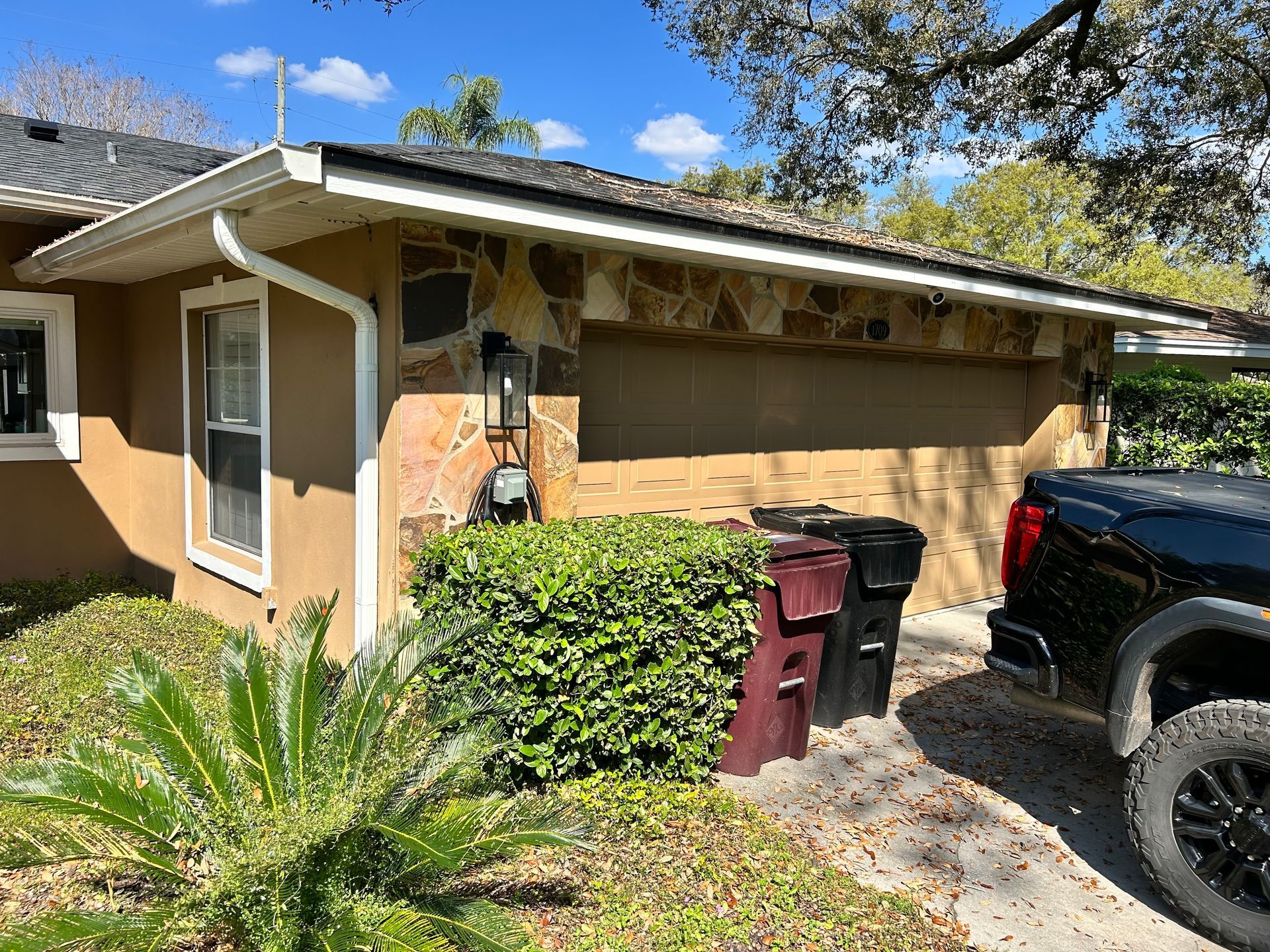 Modern kitchen with white and natural wood cabinets, stainless steel appliances, and a dining area.