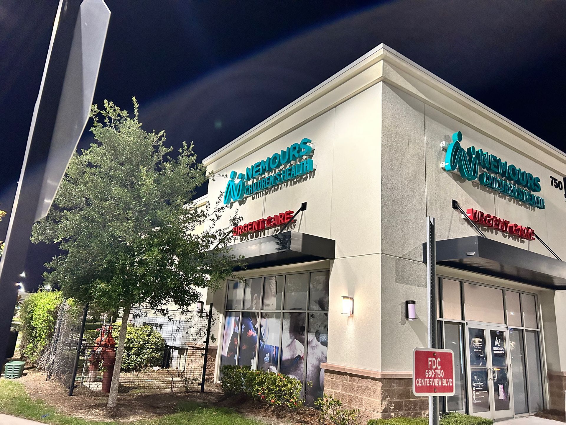 Double wooden front doors with wreath and doormat.