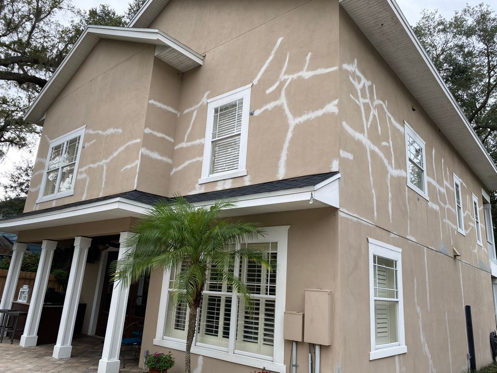 Damaged brick mailbox on a residential street; bricks are broken and fallen on the ground next to the post.