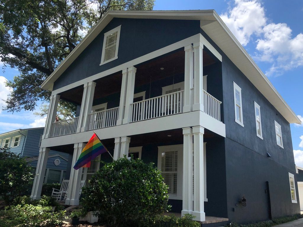Man installing wood-look flooring. Indoors, construction in progress. Floor and wall protection visible.