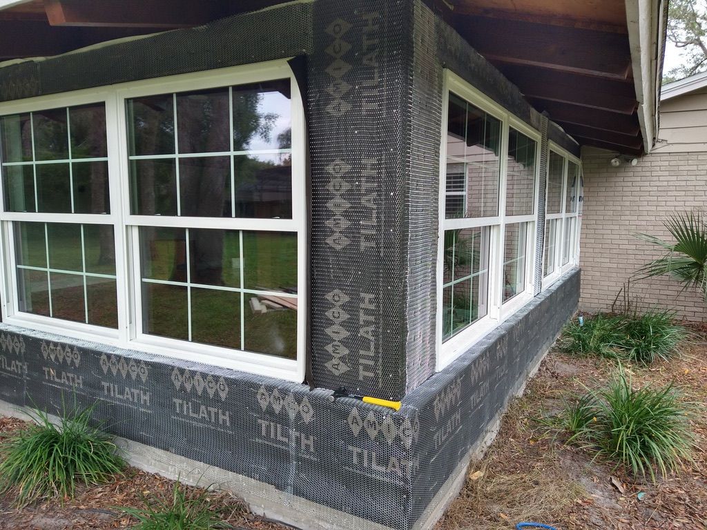 Modern kitchen with white and natural wood cabinets, stainless steel appliances, and a dining area.