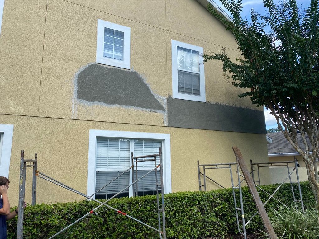 Bedroom with wood flooring, green accent wall, bed, and TV on a table by a window.