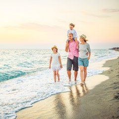 A family is walking along the beach.