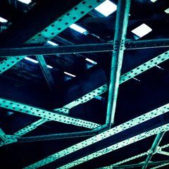 Looking up at the ceiling of a building with green beams