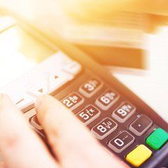 A person is using a credit card machine to make a payment.