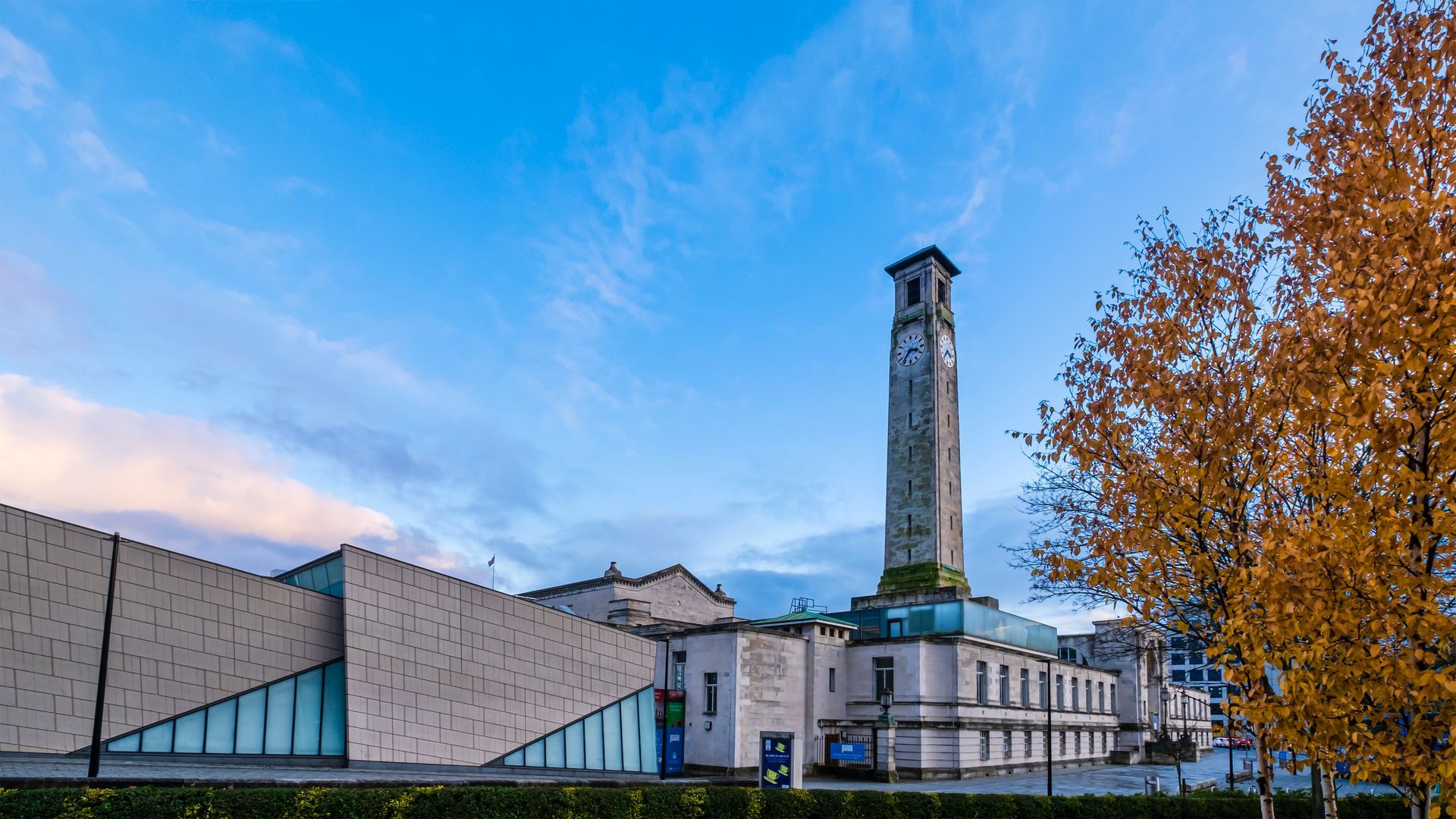 A large building with a clock tower in front of it.