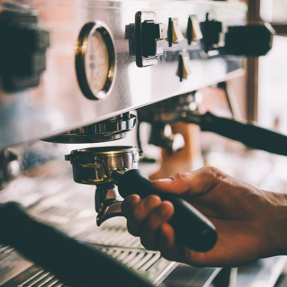 A close up of a person using a coffee machine