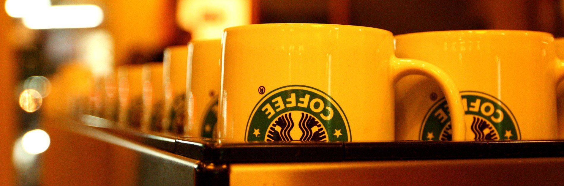 A row of starbucks coffee mugs on a shelf
