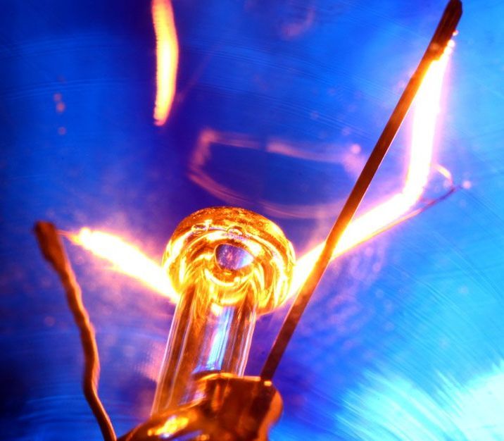 A close up of a light bulb with a blue background