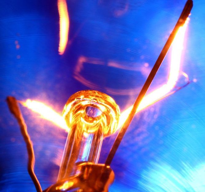 A close up of a light bulb with a blue background