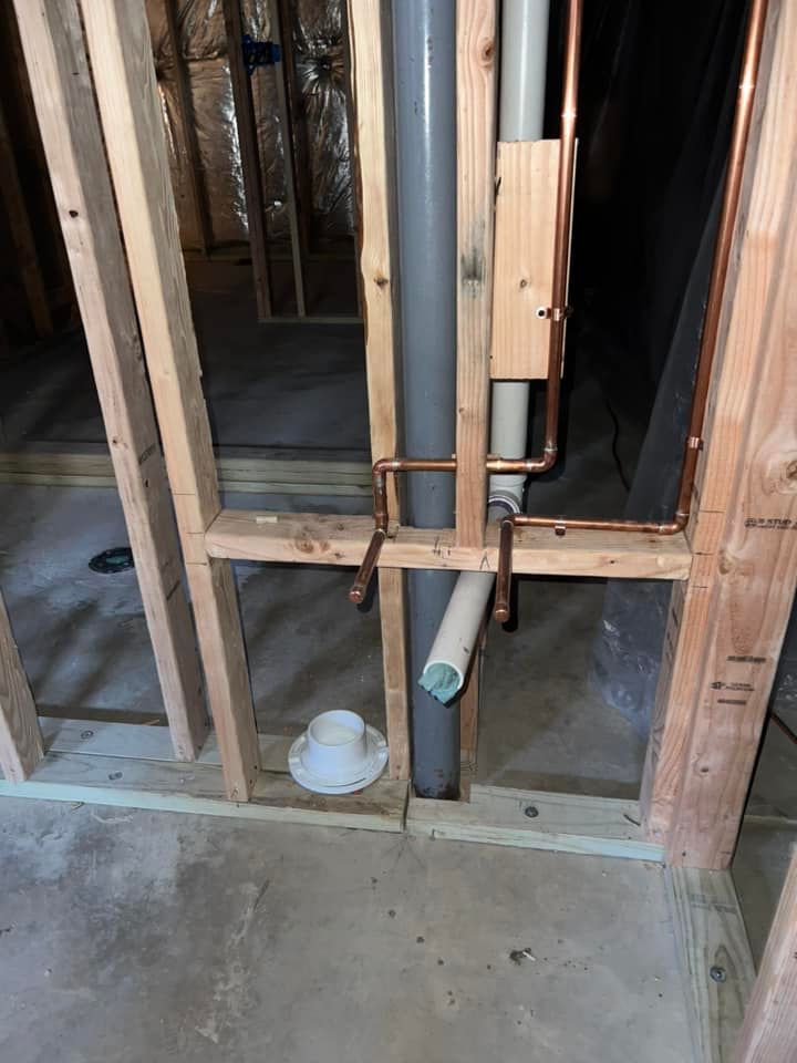 A pipe is being installed in a bathroom in a house under construction.