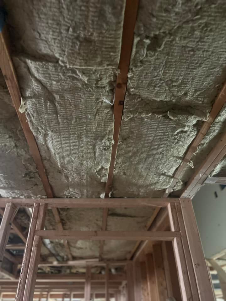 The ceiling of a house is insulated with foam and is being built.
