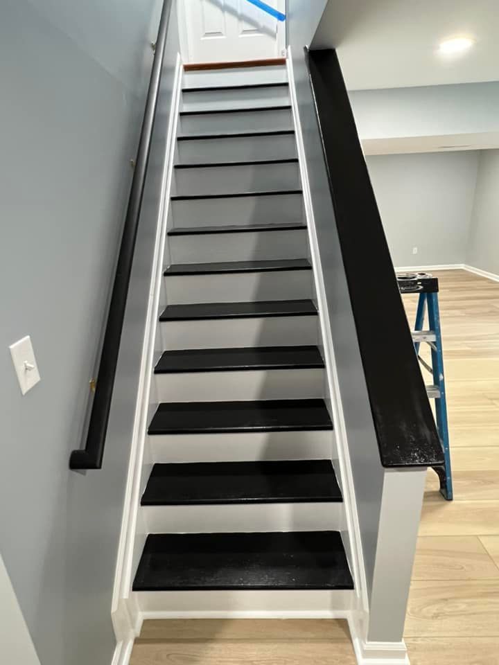 The stairs are painted black and white and have a black railing.