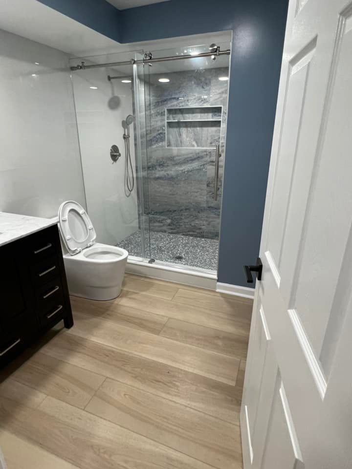 A bathroom with a toilet , sink , and walk in shower.