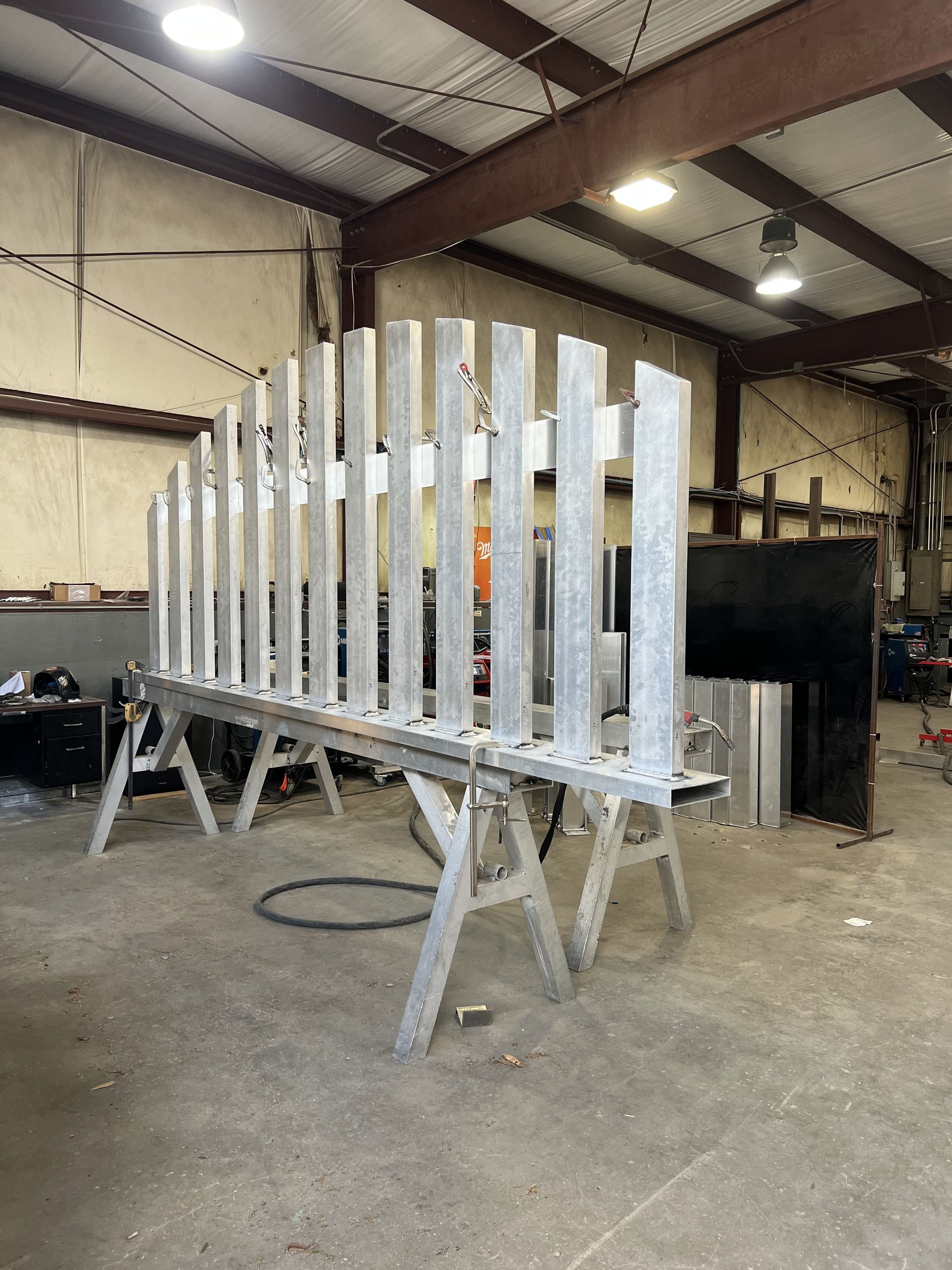Metal framework structure on sawhorses inside a workshop.
