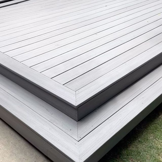 A close up of a gray wooden deck with steps.