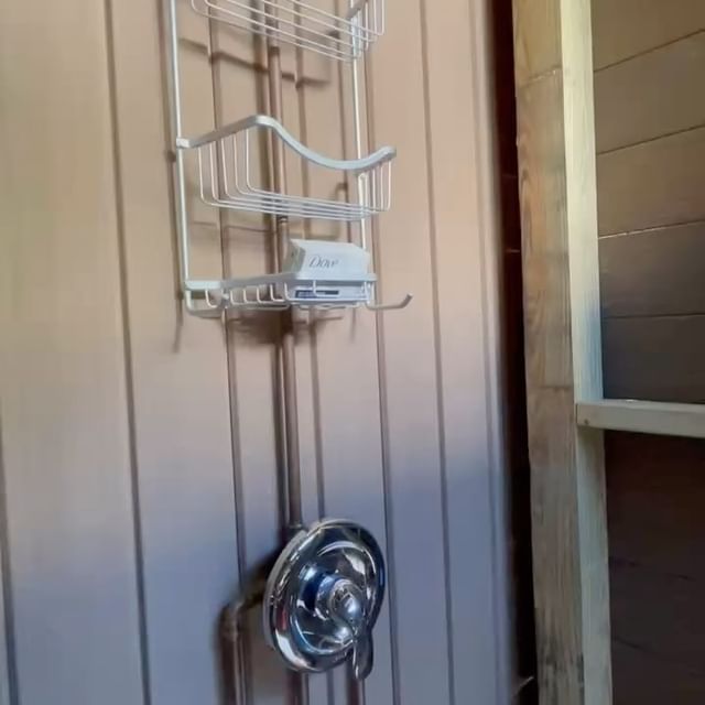 A bathroom with a shower caddy hanging on the wall
