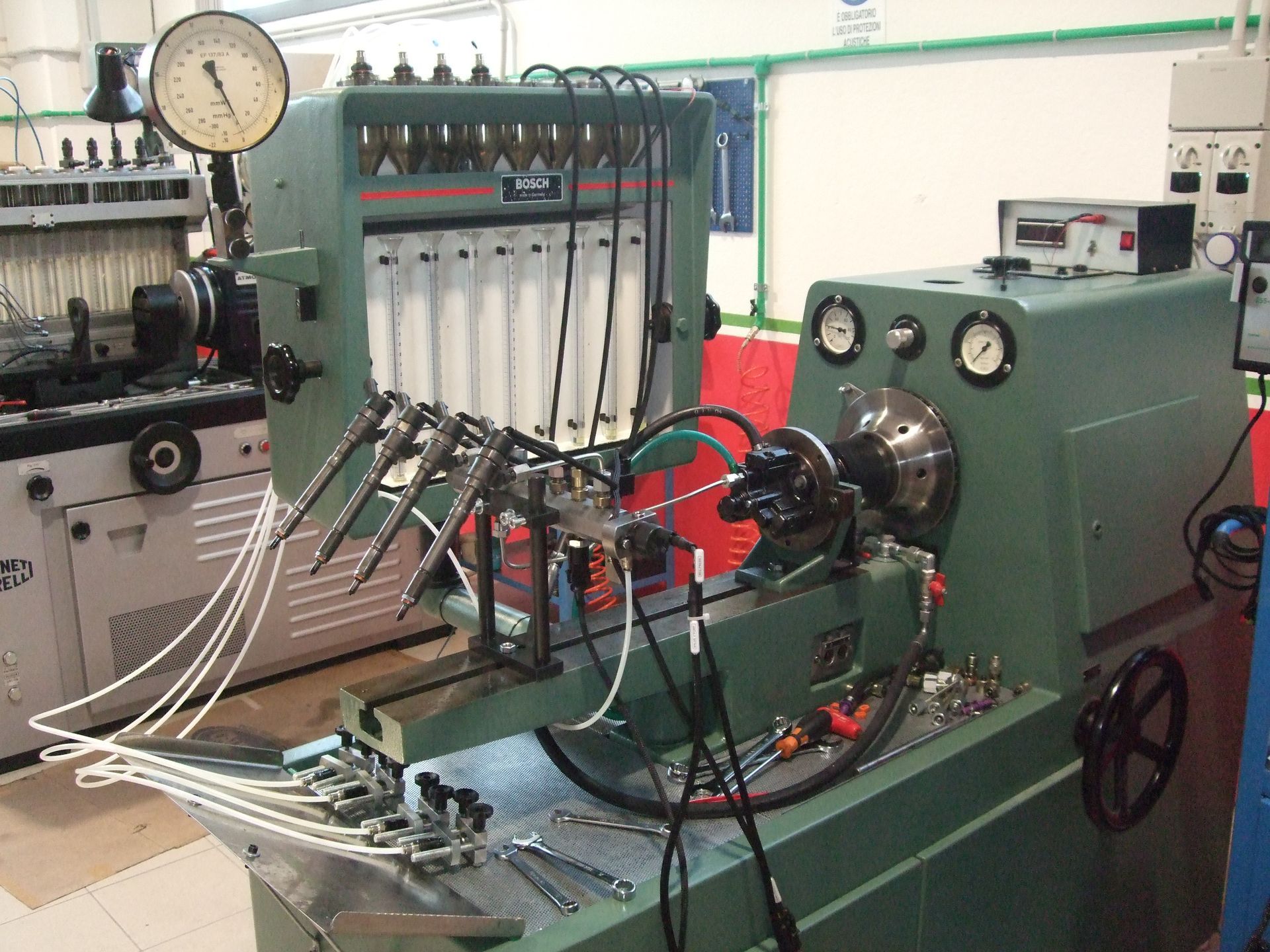 Macchina per la prova degli iniettori diesel in un'officina. Verde, con manometri e iniettori.