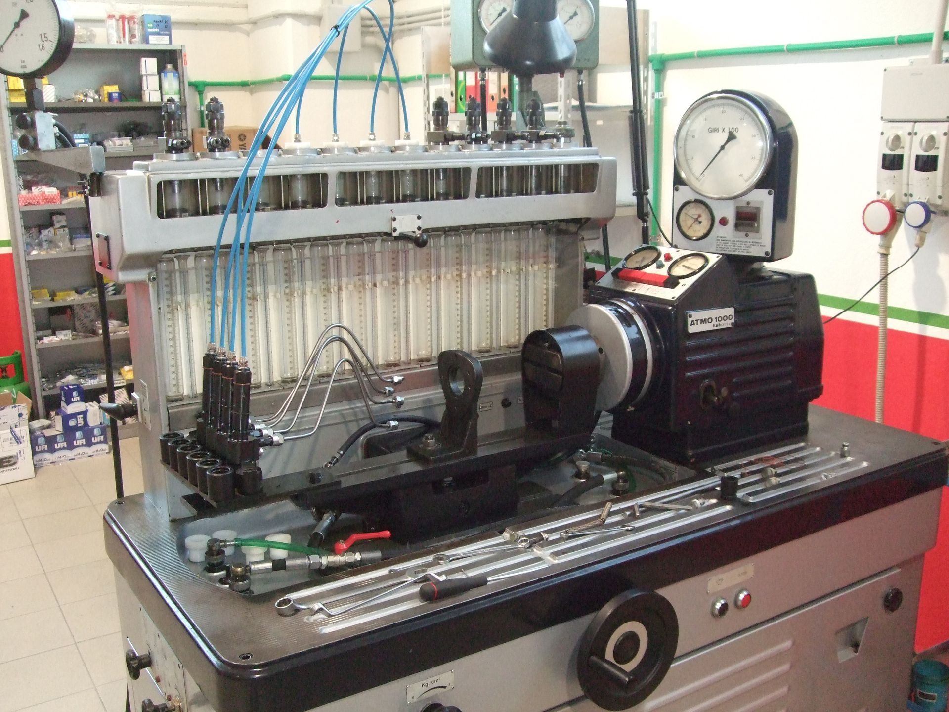 Macchina per la prova degli iniettori di carburante in un'officina, con manometri, tubi e supporti per iniettori.