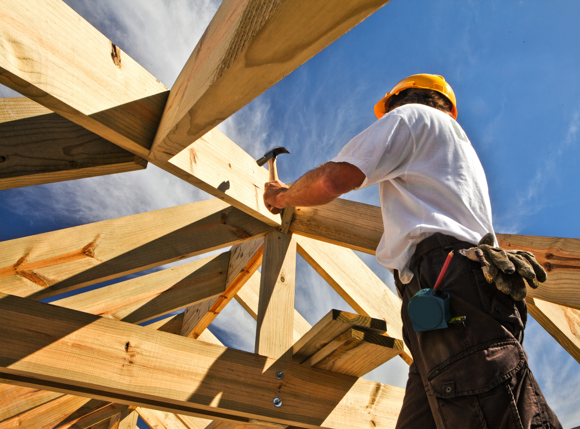 A man is working on a wooden structure with a hammer