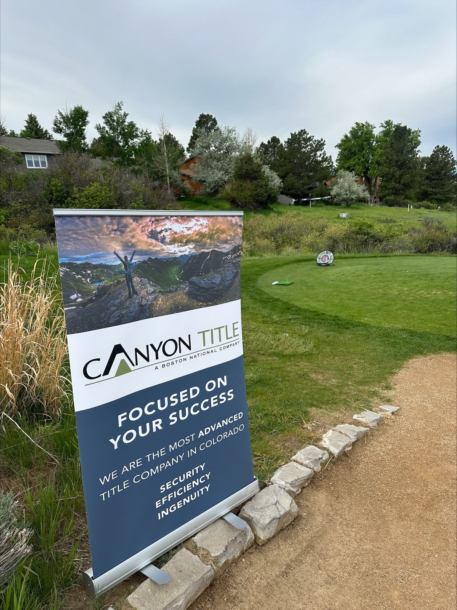 A canyon title sign is sitting on the side of a golf course.