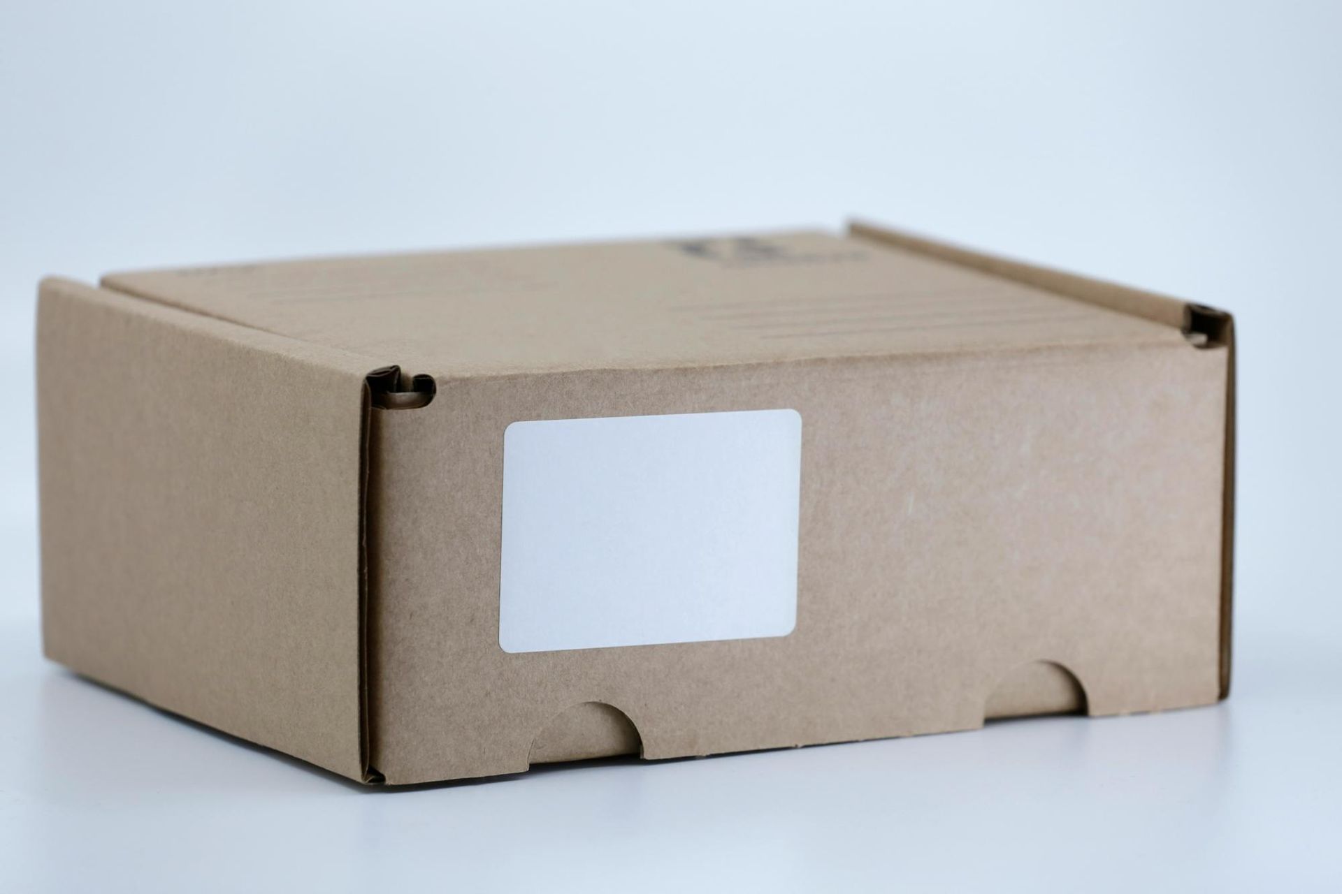 Cardboard box with a blank white label.