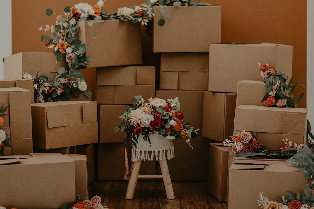 Cardboard boxes stacked with floral arrangements.