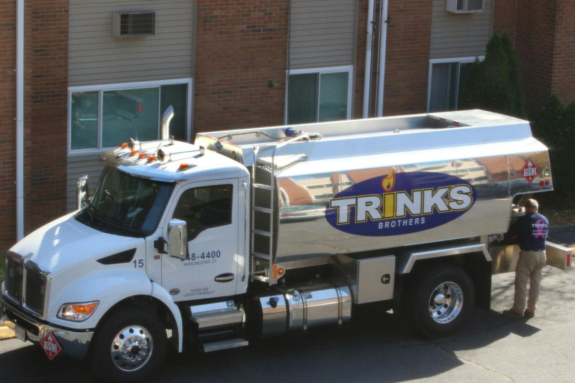 White TRINKS Eastern fuel truck parked near a building; a person stands at the side.