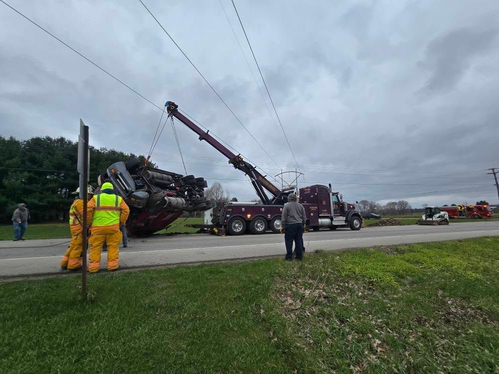 A yellow school bus is on its side and being towed by a tow truck A yellow school bus is on its side and being towed by a tow truck