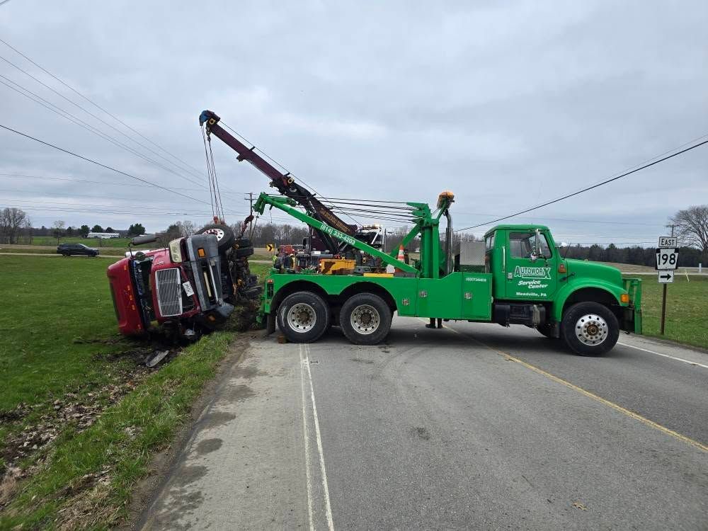 A yellow school bus is on its side and being towed by a tow truck