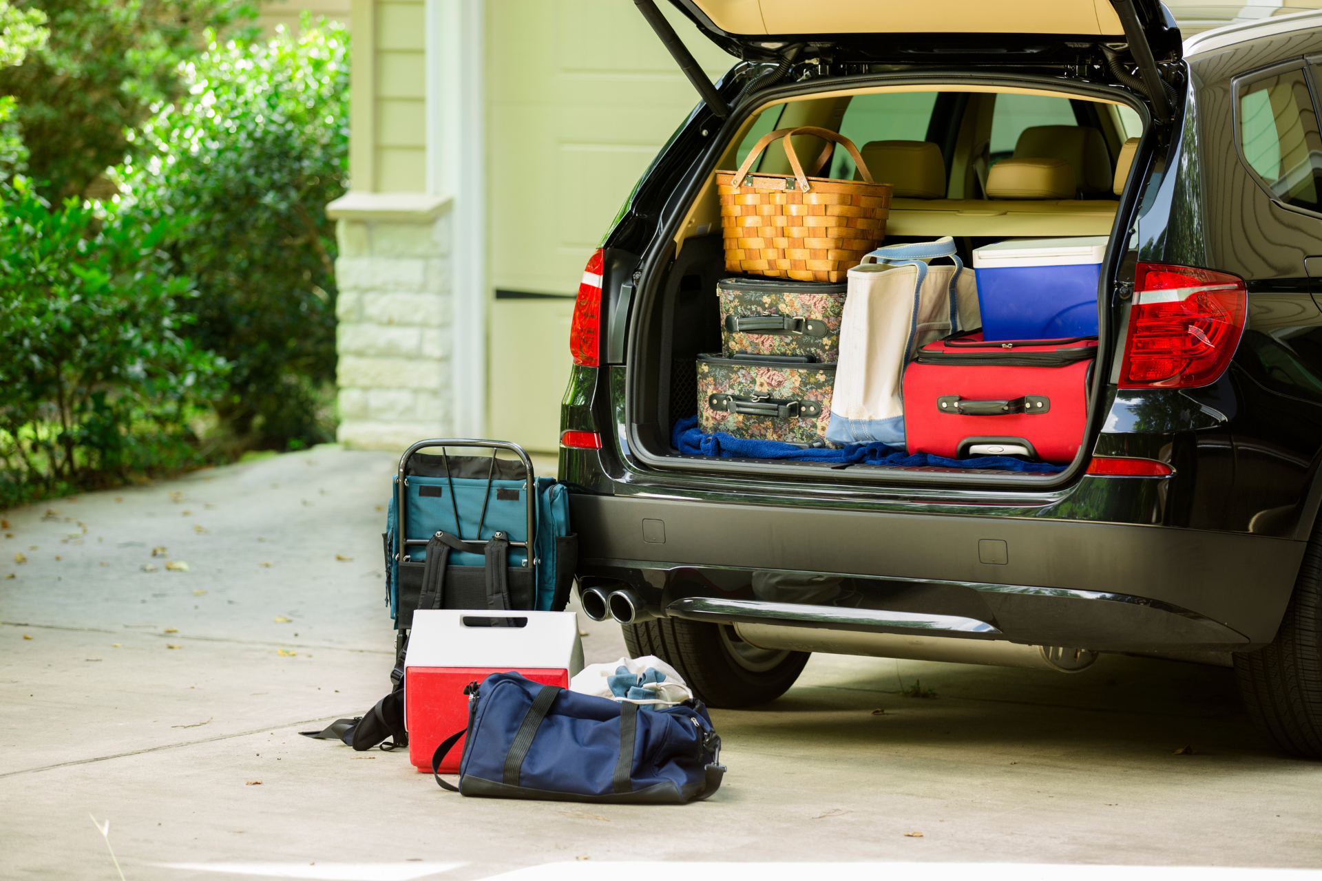 The back of a car is full of luggage and a cooler