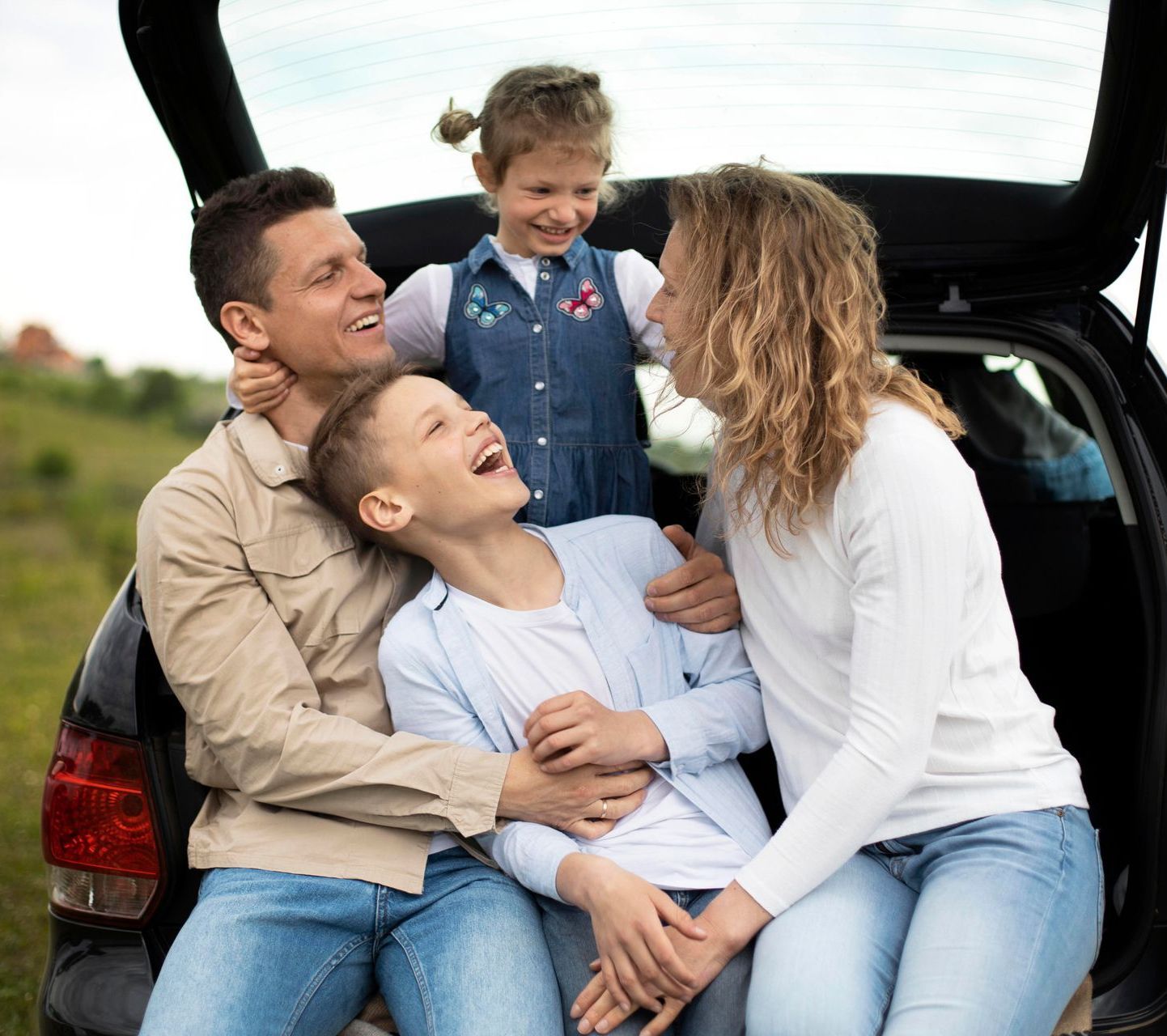 A family is sitting in the back of a car.