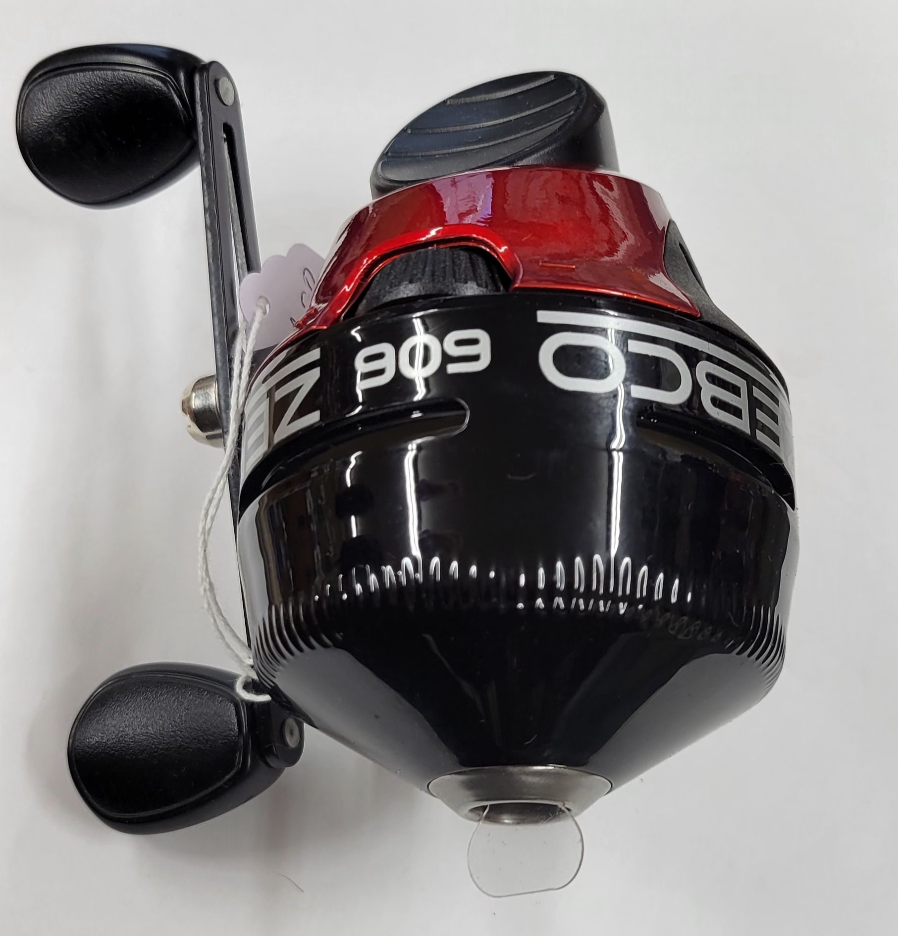 Black and red Zebco 909 Z-series spincast fishing reel with a black handle, a white tag, and clear line coming out.